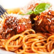 a plate of spaghetti and sausage meatballs
