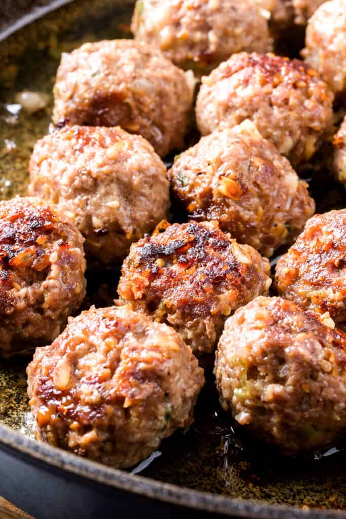 sausage meatballs frying in a pan
