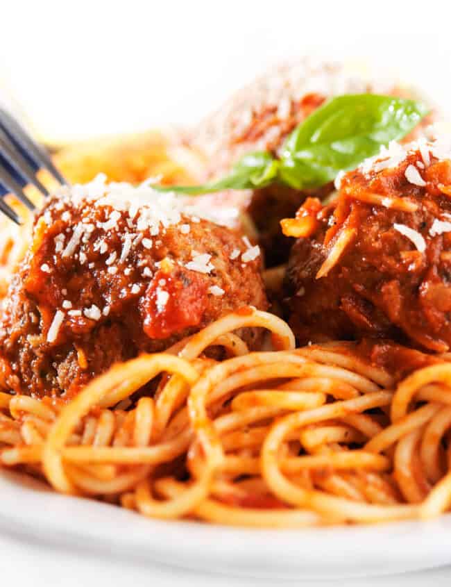 a plate of spaghetti and sausage meatballs
