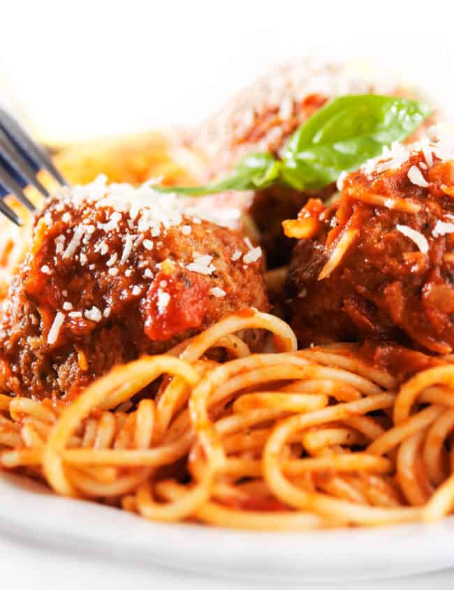 a plate of spaghetti and sausage meatballs