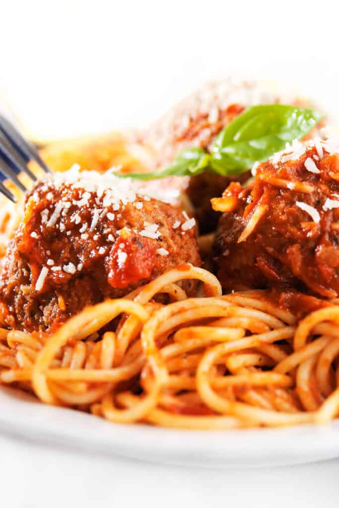 a plate of spaghetti and sausage meatballs