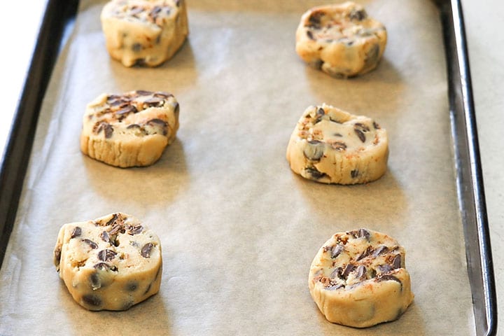 The slices of cookie dough on the pan ready to bake