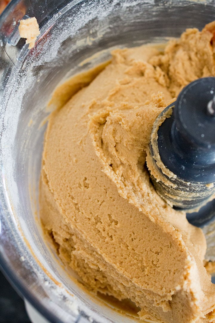 A food processor bowl with the cookie dough blended with the flour
