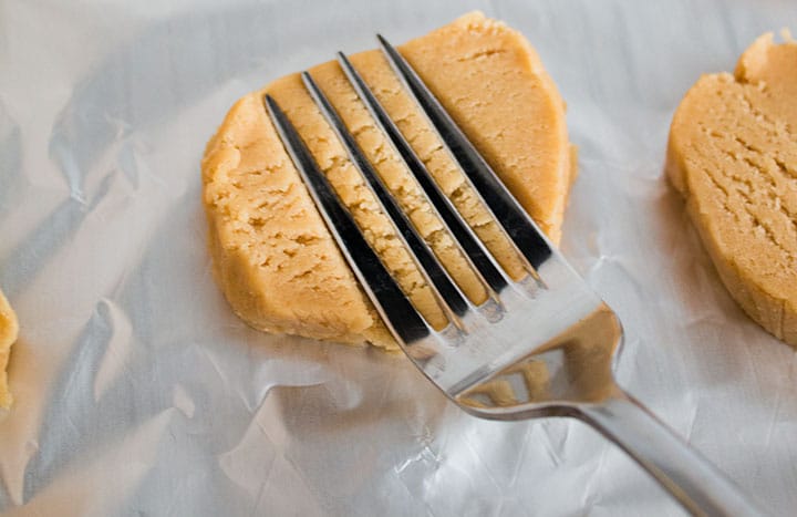 A sliced disc of dough with a fork making indents into it