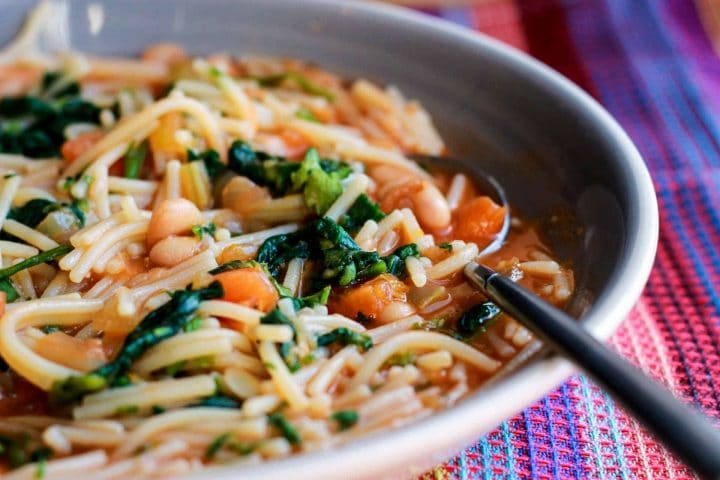 A close up of Ribollita Italian Soup In a bowl with a spoon going into it.