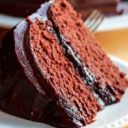 A close up of a slice of devils food cake with chocolate icing