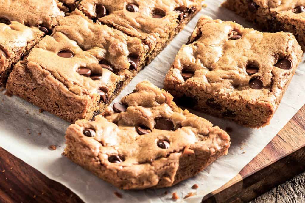 a close up of chocolate chip blondies cut into squares