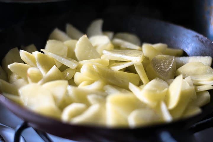 potatoes coated in oil in a pan