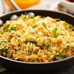 Vegetarian Rice Pilaf in a pan with dishes of vegetables in the background