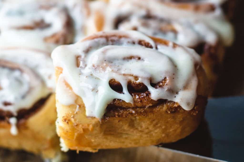 a glazed cinnamon roll being served