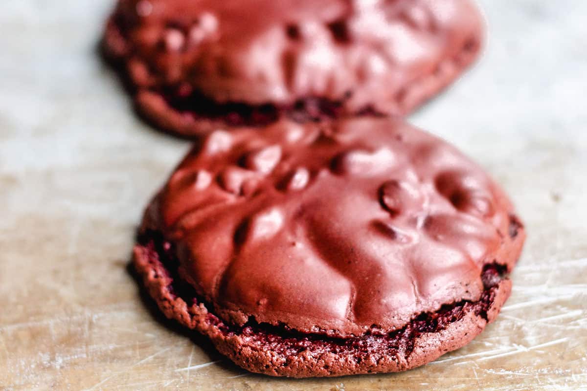 two red velvet cookies lines up on a tray