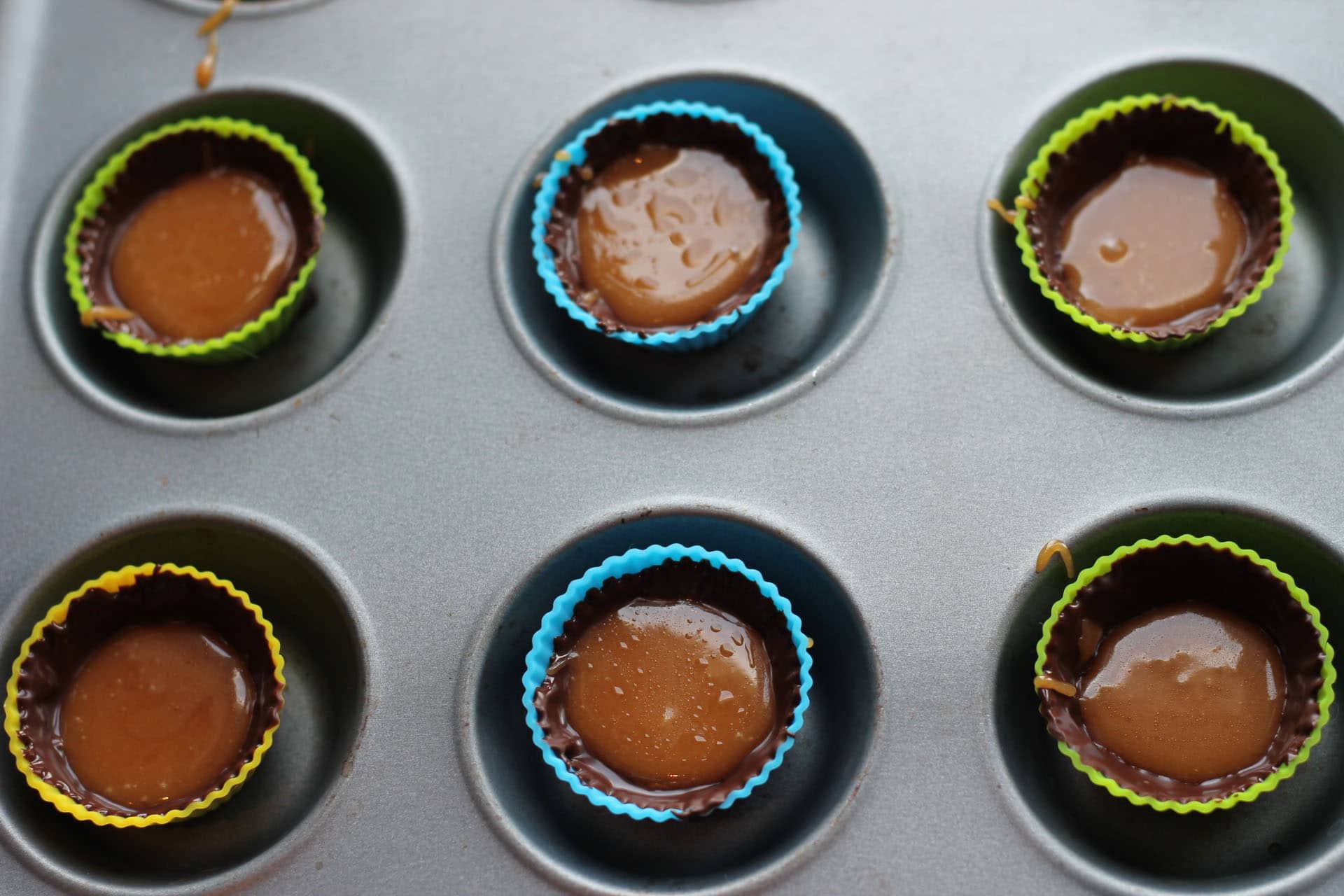 chocolate molds with melted chocolate and caramel