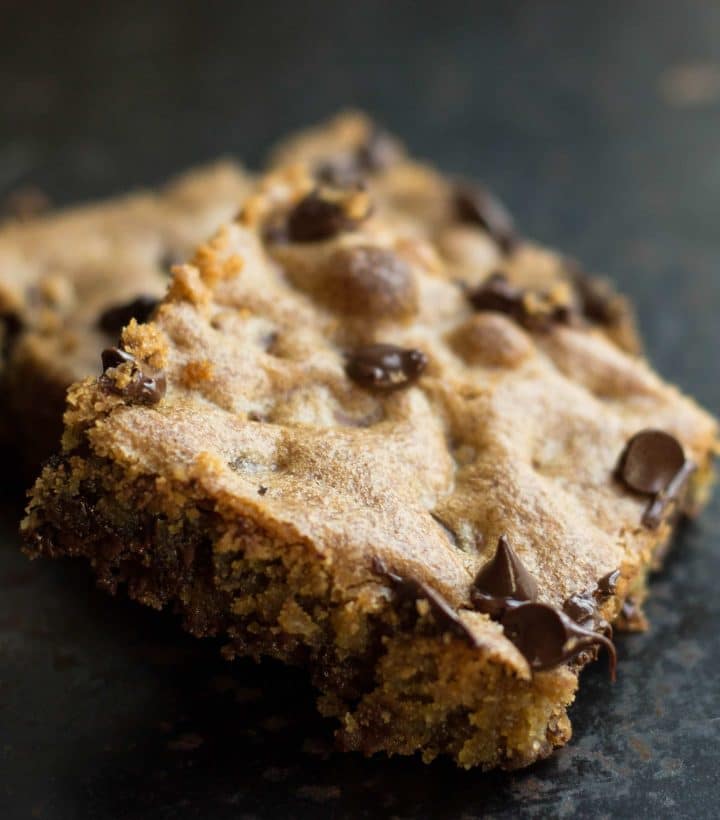 Two slices of Classic Chocolate Chip Blondies still warm with melted chocolate chips