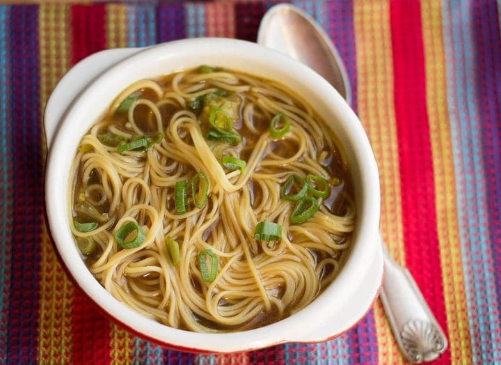 Quick & Easy Chinese Noodle Soup in a bowl, scattered with green onions with a spoon next to it