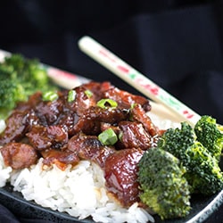 slow cooker honey soy chicken on a bed of rice with chopsticks