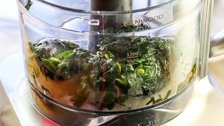 The spinach and garlic added to a food processor