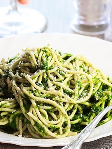 A bowl of Spaghetti with Spinach Sauce with a fork next to it on the plate