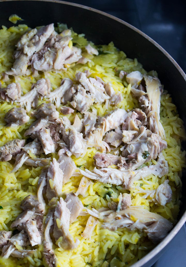 The chicken added to the saffron rice in the pan