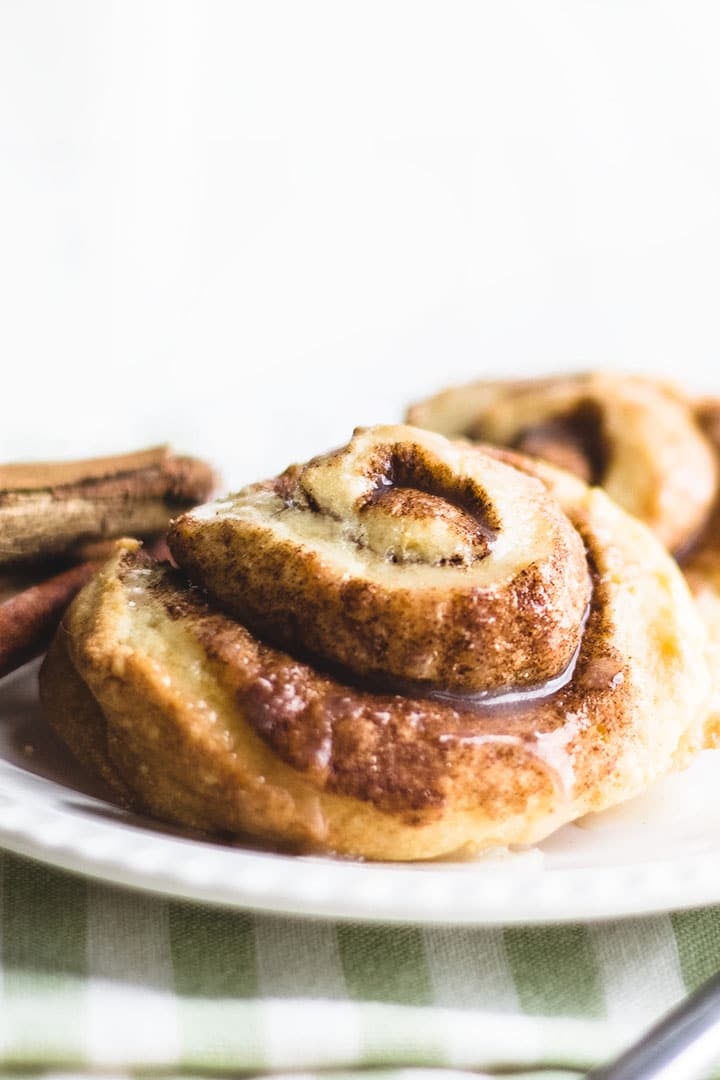 Cinnamon Swirl Scones on a plate with cinnamon sticks