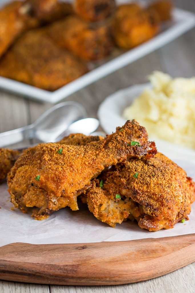 Three pieces of Easy Oven Fried Chicken speckled with parsley