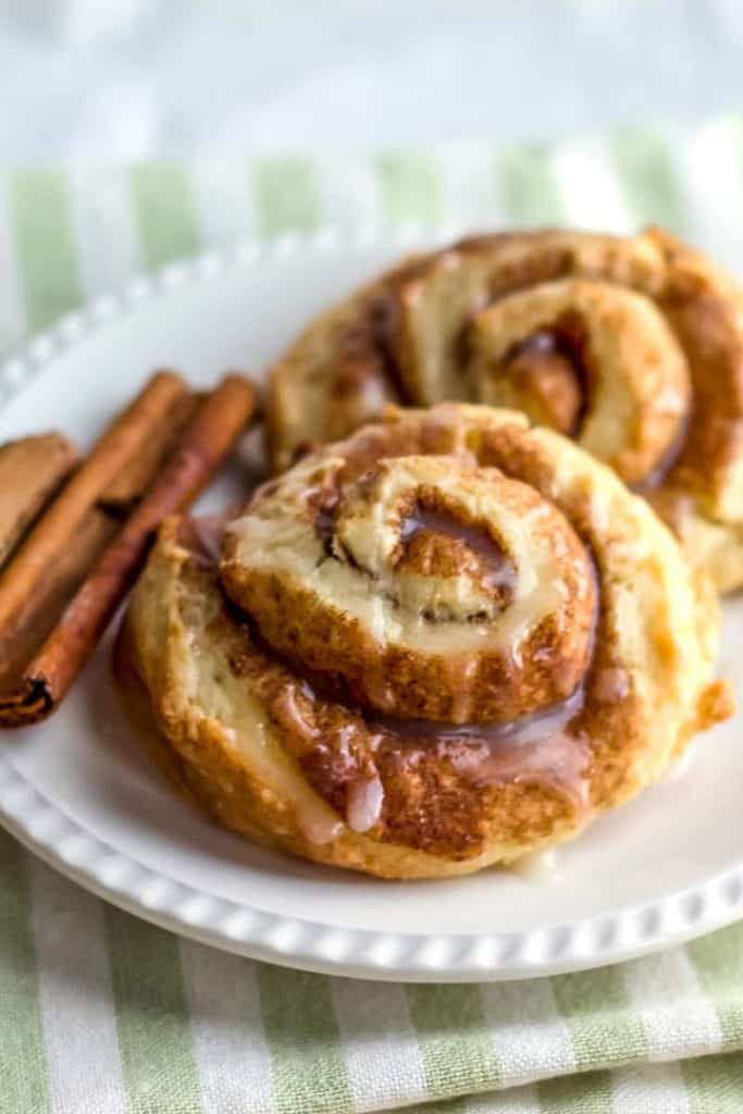 Cinnamon Swirl Scones on a white plate with cinnamon sticks next to it