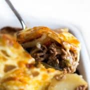 a spoon serving cottage pie stopped with cheesy potatoes