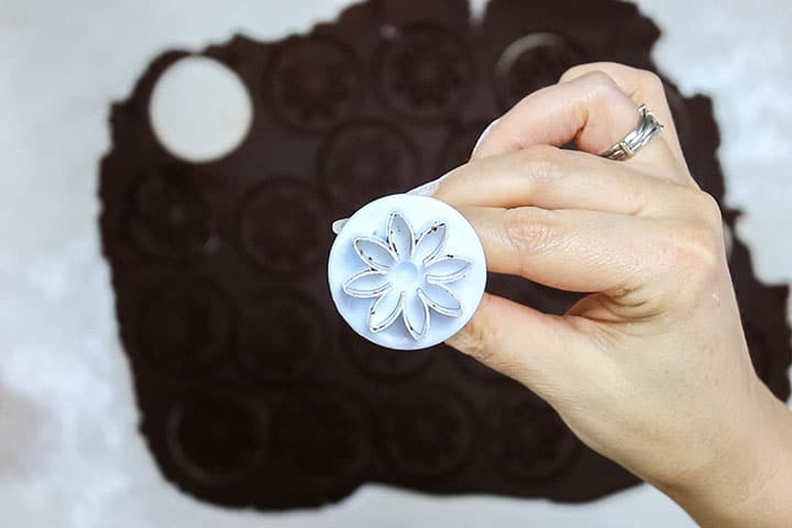 A flower fondant press above the cookie dough on the table