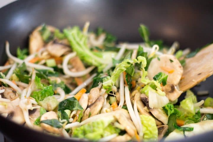 stir fry vegetables added to the wok with the onions garlic and spring onions