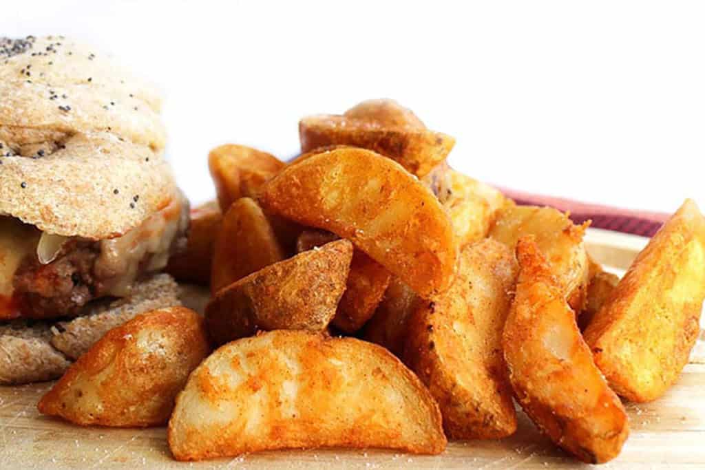 crispy Potato Wedges on a plate with a burger