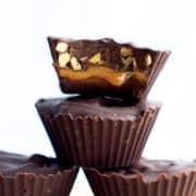 4 homemade snickers candies with one cut open to see the caramel and peanuts inside