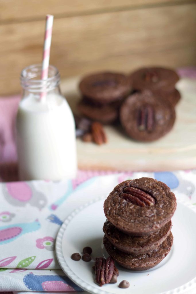 Triple Chocolate Brownie Bites on a plate with a bottle of milk and more brownies in the background.