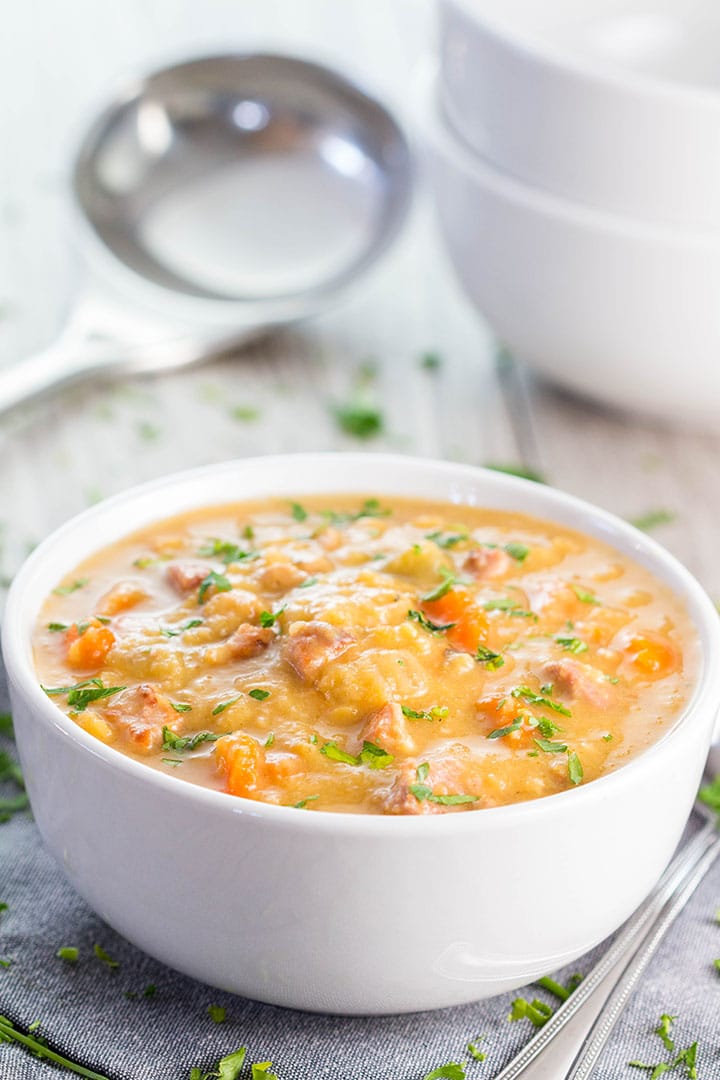 A bowl of Yellow Split Pea and Bacon Soup with a ladle in the background