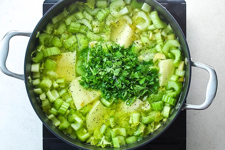 The potatoes and parsley added to the pot with the soup