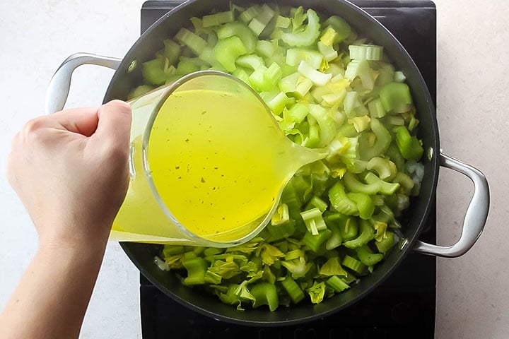 The stock being added to the pan