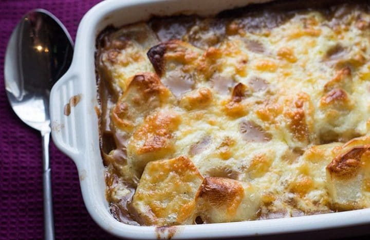 A pan of cottage pie topped with cheese and potatoes