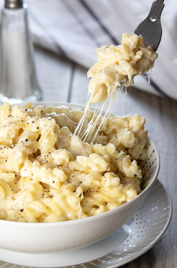 A forn digging into a big bowl of Homemade Creamy Mac and Cheese