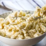 A fork digging into a big bowl of Homemade Creamy Mac and Cheese