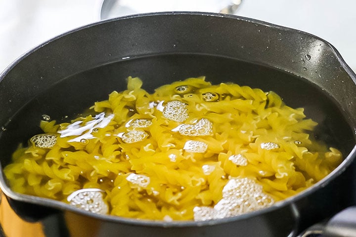 The pasta cooking in the water