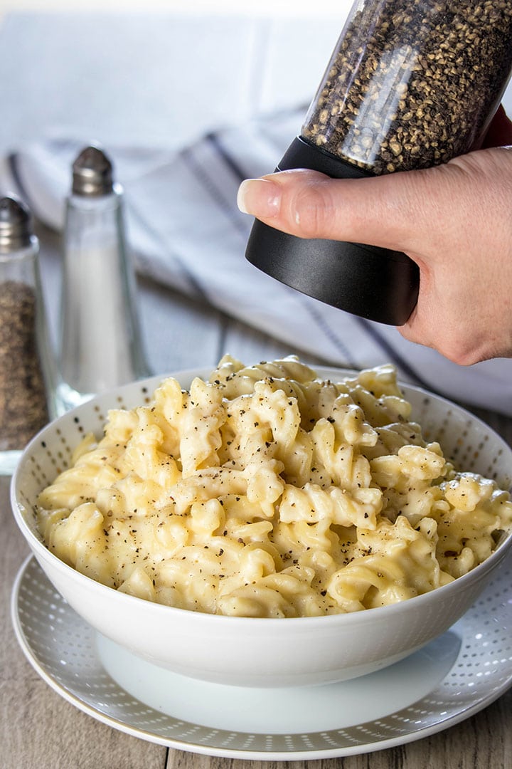 Pepper being ground over Homemade Creamy Mac and Cheese