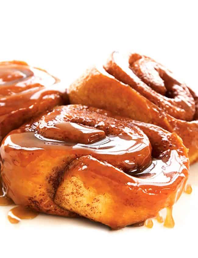 Three sticky buns covered in gooey sweet sauce