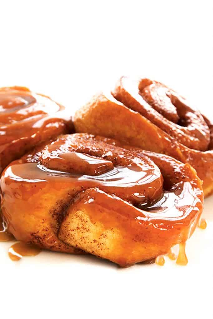 Three sticky buns covered in gooey sweet sauce