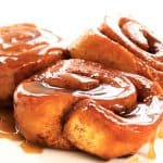Three sticky buns covered in gooey sweet sauce
