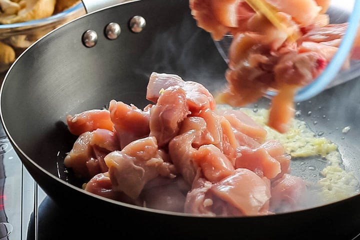 The chicken added to the wok with the garlic and ginger