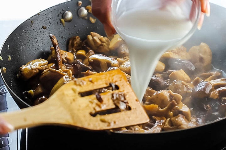 The cornstarch mixture being poured into the wok