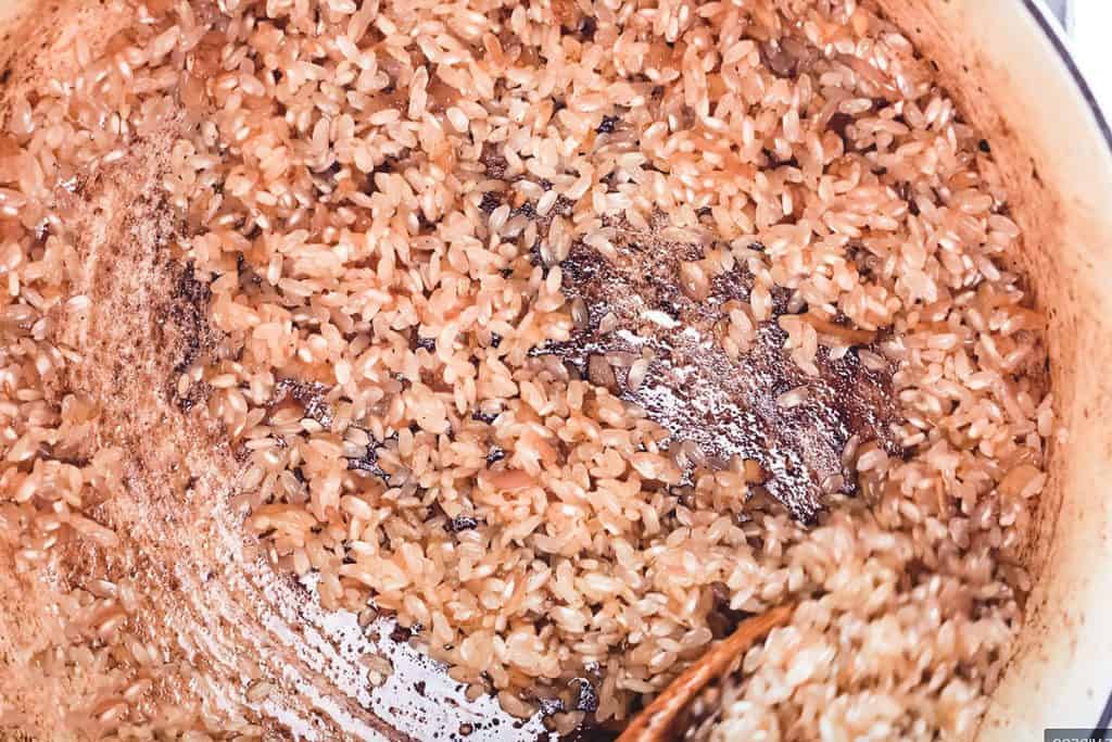 the rice added to the pan coated in the shallot mixture