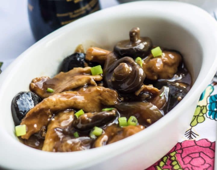 Chicken with Chinese mushrooms in a deep, rich sauce scattered with green onions