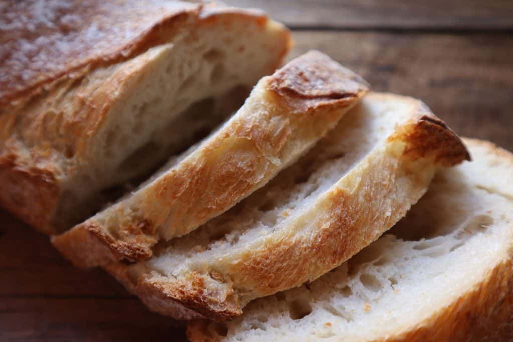 a loaf of crusty bread cut into thick slices