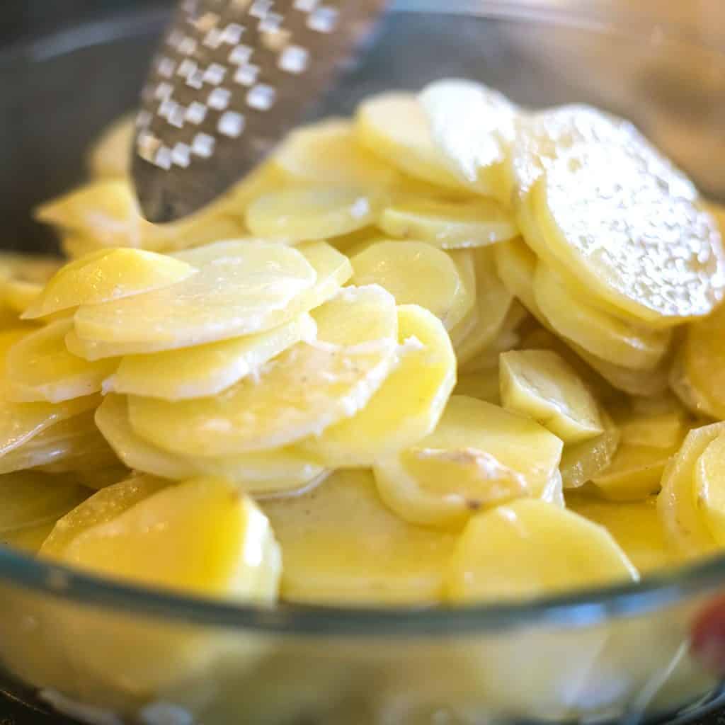 a bowl with cream and potato slices