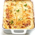 a dish of cheesy scalloped potatoes ready to serve.