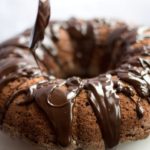 chocolate mayonnaise cake with chocolate ganache being drizzled on to it with a spoon